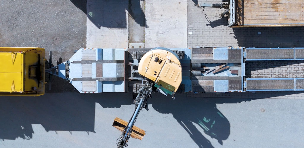 Luftaufnahmen von Bagger und Anhänger auf Baugelände von Swing & Cut